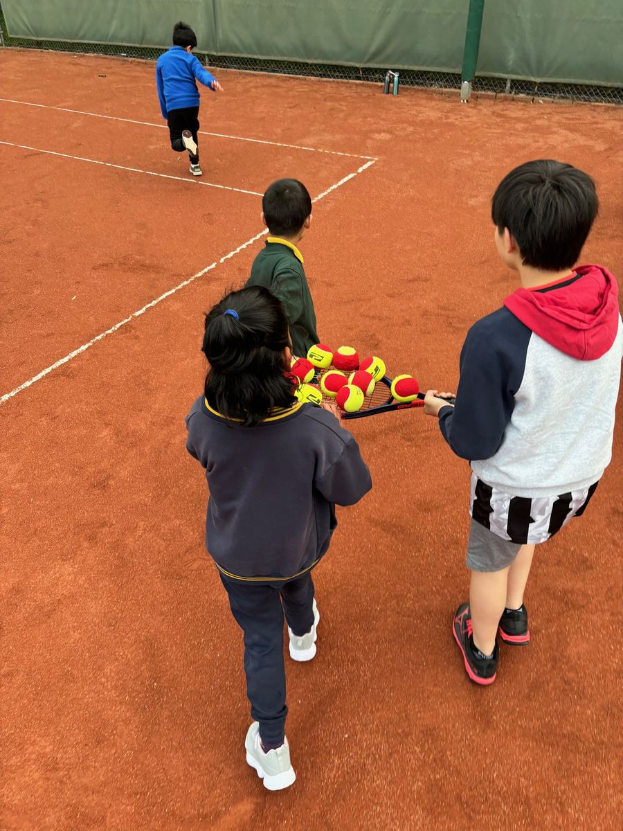 Coach working with junior players during a group class at Temp Tennis, Holy Saviour Tennis Club, Vermont South